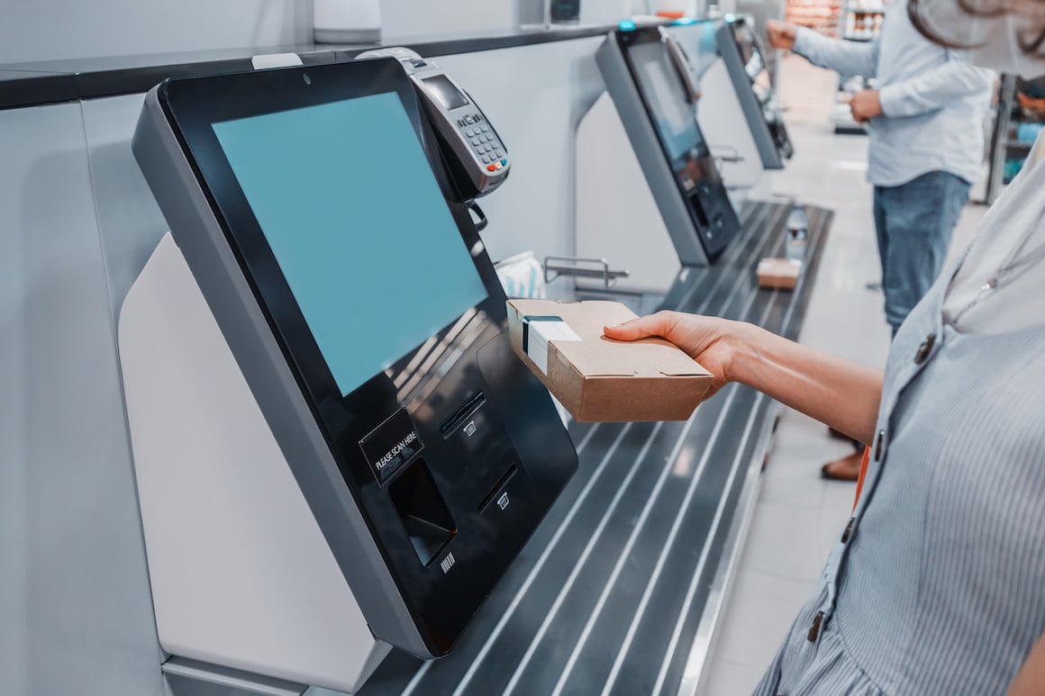 person scanning box at self checkout